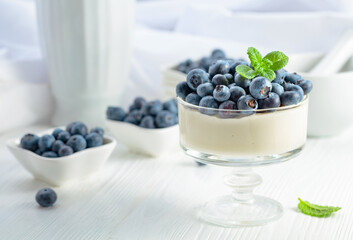 Mascarpone cream with fresh blueberries in a clear bowl.