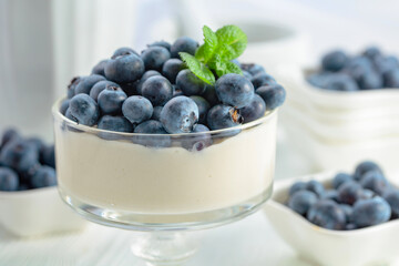 Mascarpone cream with fresh blueberries in a clear bowl.