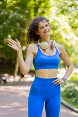 Hello, welcome. Athletic fit slim runner adult girl waving hi with her palm greeting with...