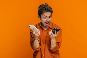 Irritated nervous stressed Caucasian man talking screaming on two mobile phones having conversation...