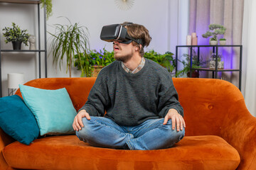 Excited man using virtual reality futuristic technology VR app headset helmet to play simulation 3D...