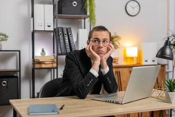 Tired Caucasian businessman thoughtful employer take break after laptop work at home office....