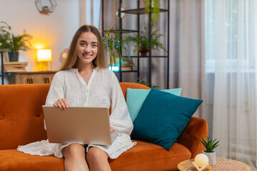 Young woman freelancer opening laptop and working on remote project. Portrait of Caucasian girl in...