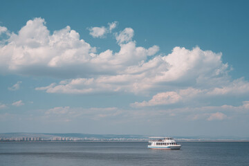 Fototapeta premium serene view of river in saratov emphasizing solitary vessel under cloudy sky
