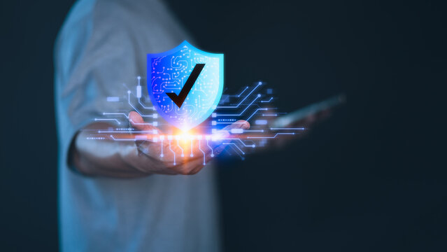 User show on hand the digital shield icon with checkmark, symbolizing cybersecurity, data protection, network safety, and trusted secure technology in a modern digital environment.