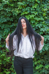 Woman with a dark long silky hair. Concept of hairstyle and beauty