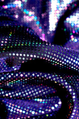 Holographic shiny spots and dots bokeh on fabric for a futuristic disco background