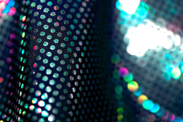 Holographic shiny spots and dots bokeh on fabric for a futuristic disco background
