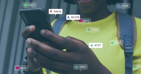 Woman holding smartphone, activating animated social media bubbles and smiling at rising counts - Powered by Adobe