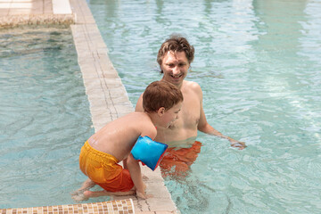 happy dad and son in the pool in summer