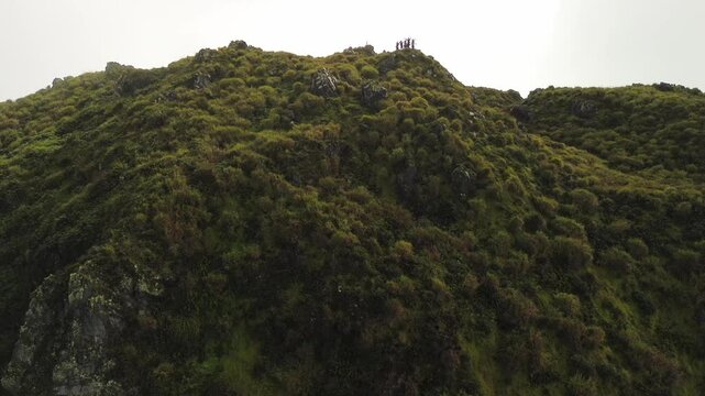 Emerald grass and volcanic boulders cloak the steep slopes of Mindanao&rsquo;s Mount Apo, rising diagonally into a bright, hazy sky in a calm aerial climb.