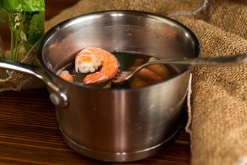 Juicy sea shrimps in a pan, on a wooden table