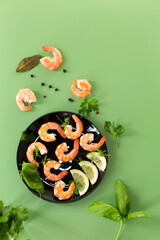 Seafood red shrimps with lemon isolated on green background