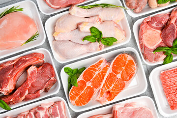 Various raw meat and fish in packaging trays from supermarket. Top view. Food background.
