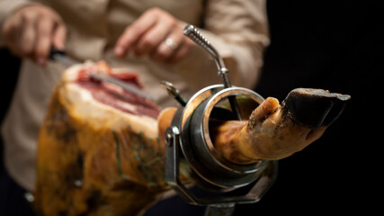 Iberian ham, Spanish ham, Iberian meat, sliced ​​by a master ham cutter. Selective focus and blurred background.