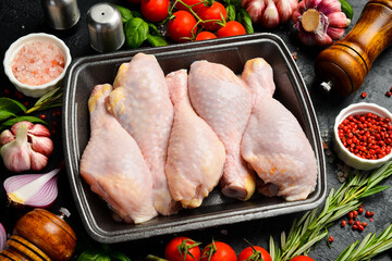 Fresh meat. Raw chicken drumsticks. Meat in a plastic black container from the market. Close-up.