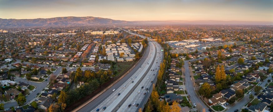 Aerial view of cars commuting on Interstate 280. Residential areas and mountains in Sunnyvale, California, USA, showcasing urban transportation and suburban living.