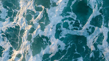 Aerial view over beautiful ocean blue waves crashing