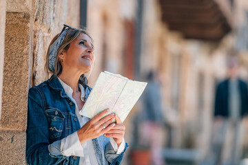 female traveler or tourist on the street with a map