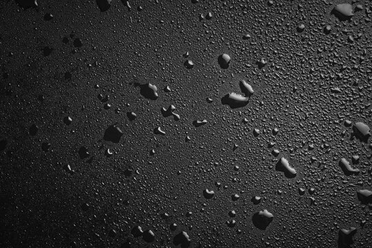 Drops of water on a black surface. The condensate. Top view. Free space.