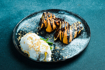Ice cream balls and pieces of banana with chocolate on a plate. Sweet dessert.