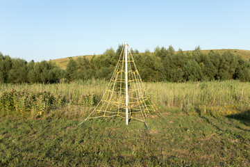 Rope net playground in green meadow. View of the rope network in the children's park. Children...