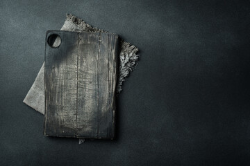 Kitchen old cutting board. Brown board. Kitchen utensils. On a dark background.