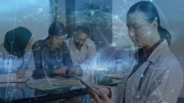 three medical doctors consulting at table while female doctor tapping tablet initiating globe grid