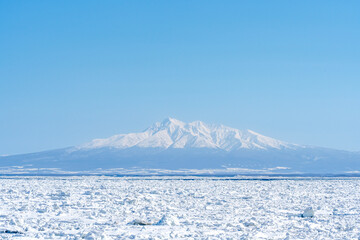 冬の北海道　オホーツク海の流氷と知床の山