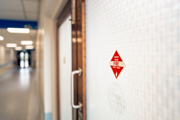 Shallow focus of a Fire Exit sign attached to old, double emergency doors located in a refurbished...