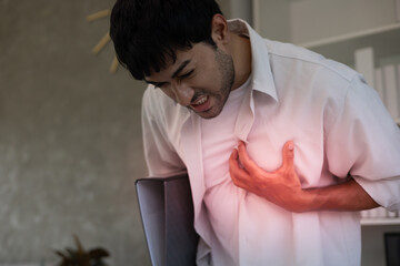 hand hold chest with heart attack symptoms,  man working hard have chest pain caused by heart...