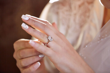 A woman is holding a ring in her hand