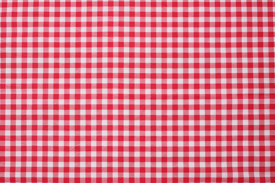 Closeup of a red and white checkered napkin or tablecloth texture. picnic cloth crumpled. Food decor element. Kitchen accessories. Top view background.
