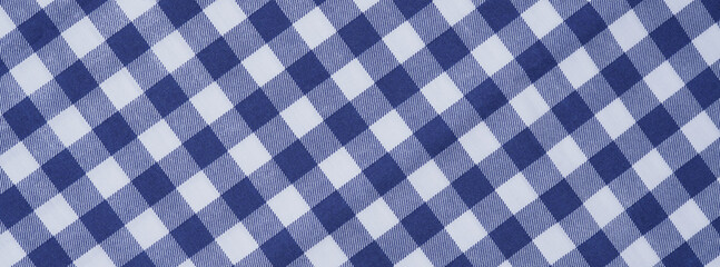 Closeup of a blue and white checkered napkin or tablecloth texture. picnic cloth crumpled. Food decor element. Kitchen accessories. Top view background.