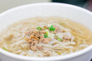 A comforting bowl of Taiwanese minced pork noodles served in a light savory broth. Tender noodles soak up the flavorful soup, topped with green onions and soy-braised pork, making it a perfect rainy d