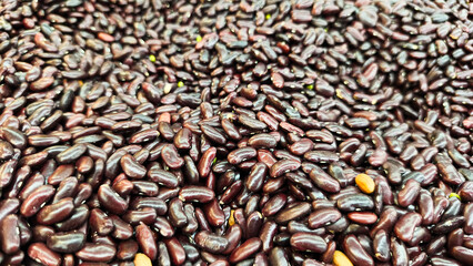 A close up of a pile of red beans, showing off their glossy texture and natural look. Ideal for concepts related to agriculture, groceries, or healthy eating.