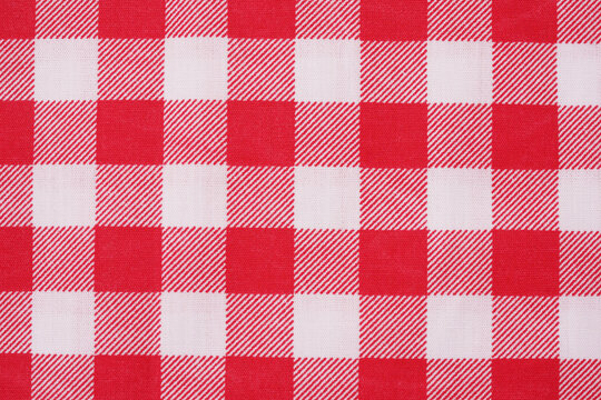 Closeup of a red and white checkered napkin or tablecloth texture. picnic cloth crumpled. Food decor element. Kitchen accessories. Top view background.
