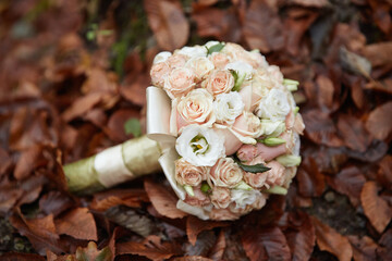 A bouquet of flowers is displayed on a leafy ground