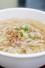 A comforting bowl of Taiwanese minced pork noodles served in a light savory broth. Tender noodles soak up the flavorful soup, topped with green onions and soy-braised pork, making it a perfect rainy d