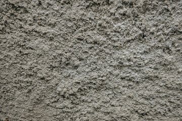 Detailed stone-like plaster texture with uneven surface gray cement wall texture with rugged, grainy surface