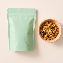 Overhead shot of a pastel green granola package next to a bowl filled with granola and dried fruit.