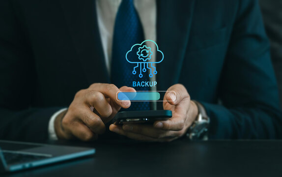 Backup concept, Online digital data storage and connection service. Businessman using smartphone with backup status bar for data backup management.