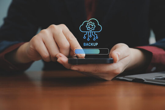 Backup concept, Online digital data storage and connection service. Businessman using smartphone with backup status bar for data backup management.