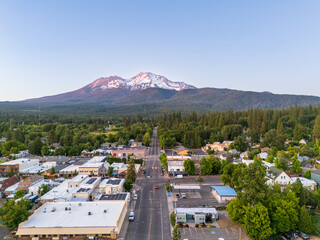 Mount Shasta volcano and town, California, USA, aerial view at sunset in summer