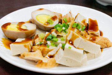 A plate of traditional Taiwanese braised snacks featuring soy-marinated egg, dried tofu, and tofu skin slices. Rich in color and flavor, this savory dish is a staple side at many local eateries