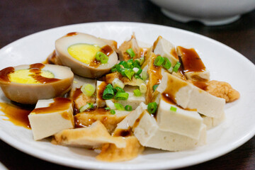 A plate of traditional Taiwanese braised snacks featuring soy-marinated egg, dried tofu, and tofu skin slices. Rich in color and flavor, this savory dish is a staple side at many local eateries