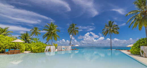 Stunning infinity pool with carefree canopy chairs loungers, umbrella under palm trees sea, peaceful tropical landscape and sunshine blue sky, perfect summer vacation leisure relaxation travel view