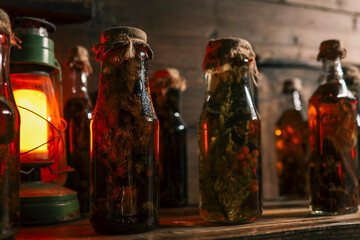 Row of vintage glass bottles filled with herbal infusions and berries on wooden shelf, glowing...