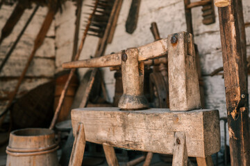 Close-up antique wooden farm press with rustic carpentry tools in traditional barn workshop, showcasing aged timber texture and craftsmanship detail