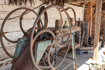Rusted iron flywheel and gear mechanism of vintage farm machinery with blue patina, displayed in...